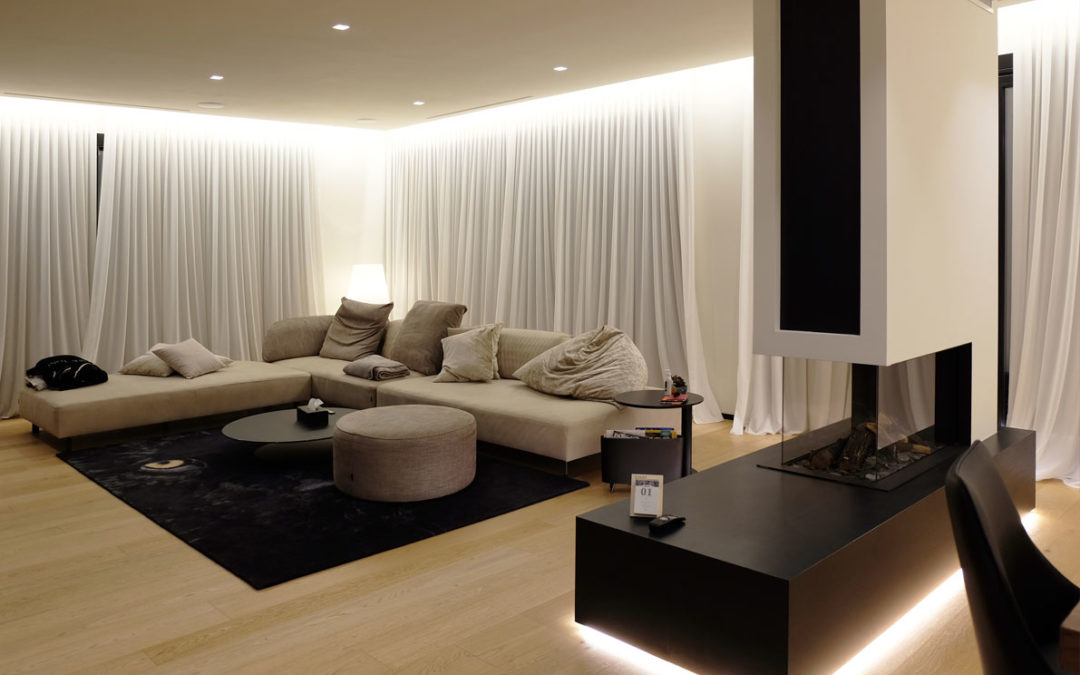 Attico con cucina con parete in Fenix e isola in Laminam