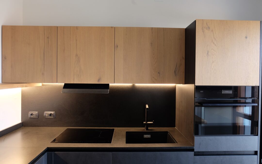 CUCINA NERA CON PIANO IN GRANITO E DETTAGLI IN LEGNO MASSELLO